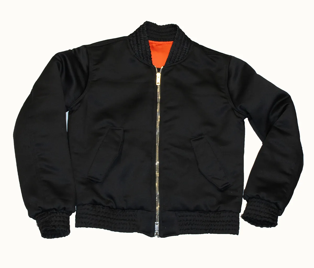 Chaqueta bomber negra con forro naranja y puños tejidos, confeccionada en el taller